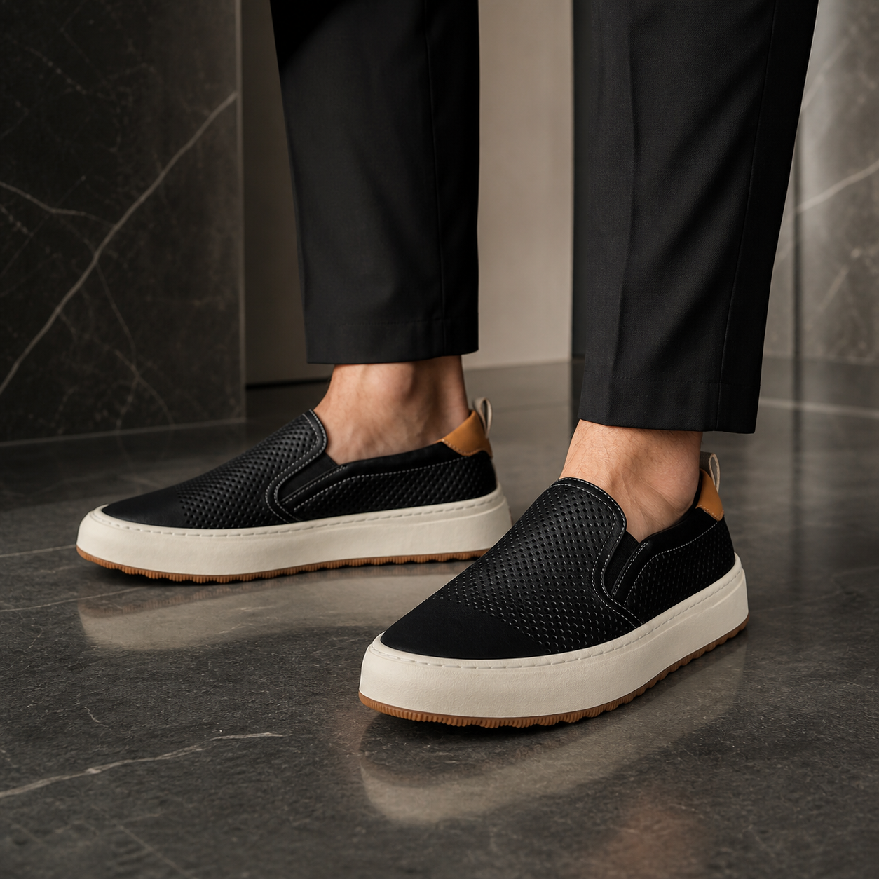Men wearing black perforated loafers in a luxury interior