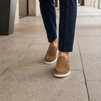 Men's brown suede loafers styled in a city arcade
