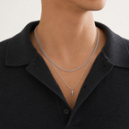 Close editorial view of layered silver curb and spike pendant necklaces