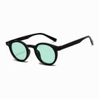 PALMA polarized round sunglasses, black frame with green lens, diagonal view on pure white